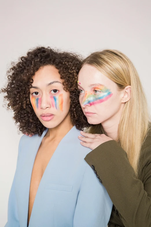 two women with face paint on their faces, an album cover, inspired by Okuda Gensō, trending on pexels, renaissance, on a white background, kailee mandel, stripe over eye, model posing