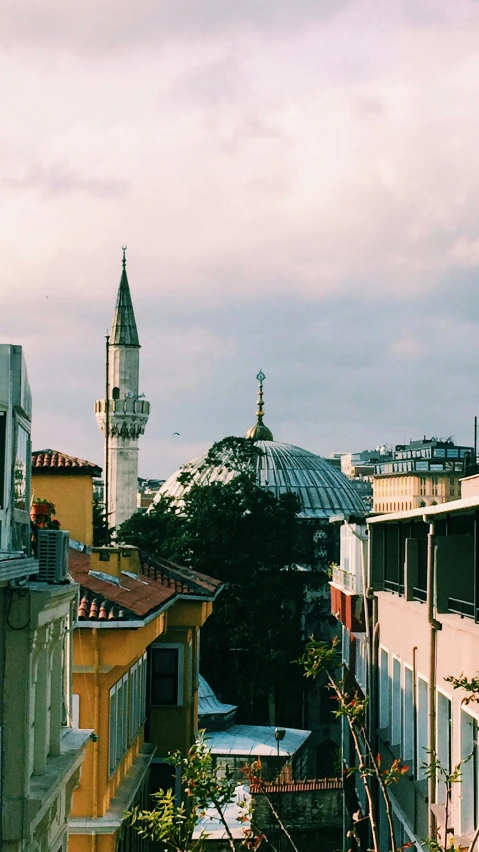 a view of a building with a clock tower in the background, inspired by Niyazi Selimoglu, unsplash contest winner, domes, neighborhood, panorama view, photo taken on fujifilm superia