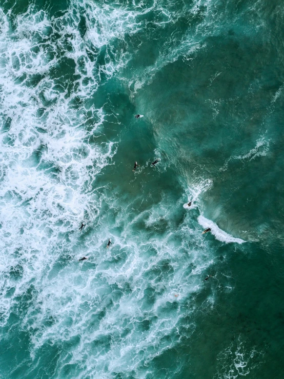 a group of people riding surfboards on top of a wave, pexels contest winner, helicopter view, bird\'s eye view, manly, ominous and intense