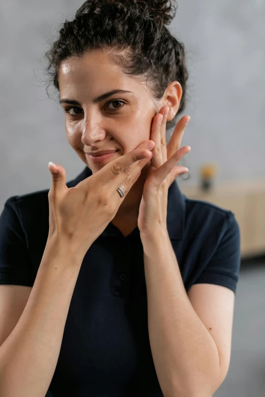 a woman touching her face with both hands, practical effects, partially cupping her hands, dimples, profile image