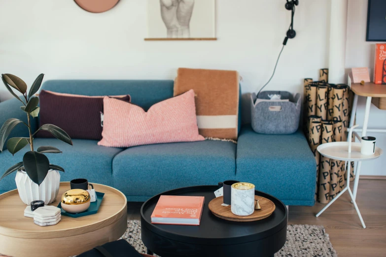 a living room filled with furniture and a blue couch, inspired by Constantin Hansen, pink and teal and orange, extra details, picton blue, studio shot