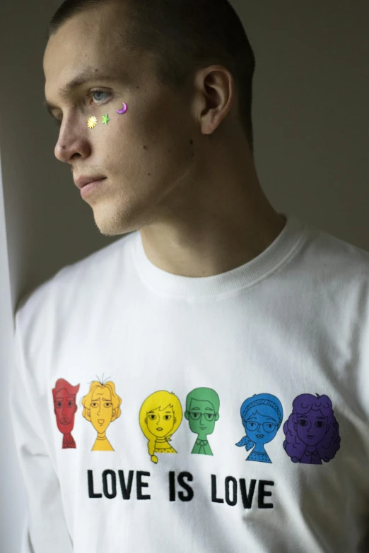 a man wearing a t - shirt that says love is love, a cartoon, trending on pexels, process art, visible pupils, non binary model, group portrait, photographed for reuters