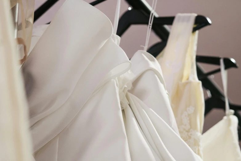 a row of wedding dresses hanging on a rack, by Alice Mason, happening, close up angle, glossy white, dynamic closeup, various items