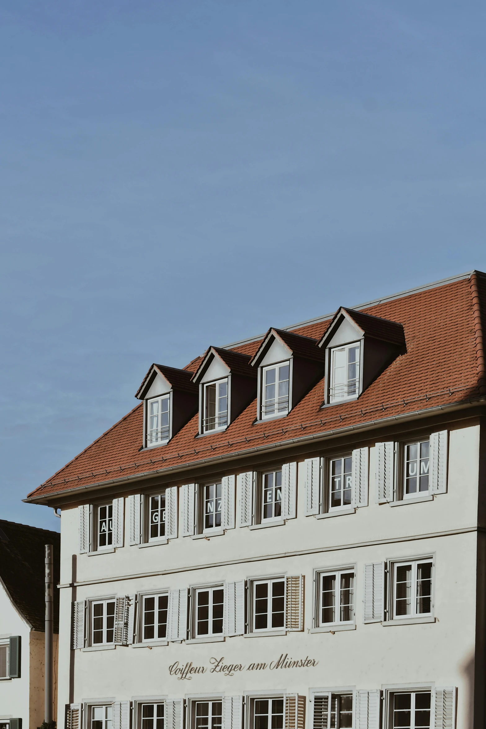 a large white building sitting on the side of a road, inspired by Karl Stauffer-Bern, pexels contest winner, with roulettes in the roof, window view, brown, elevation view