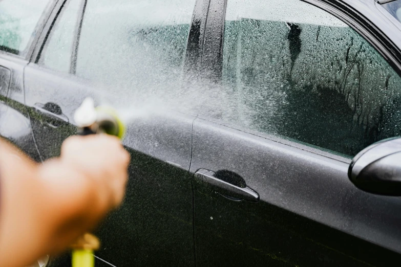 a person spraying a car with a hose, a stipple, pexels contest winner, police calling for back up, dirty windows, derealisation, 2 0 % pearlescent detailing