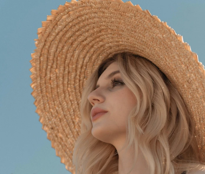 a woman wearing a straw hat against a blue sky, pexels contest winner, medium blonde, pokimane, {perfect face}, perfectly shaded