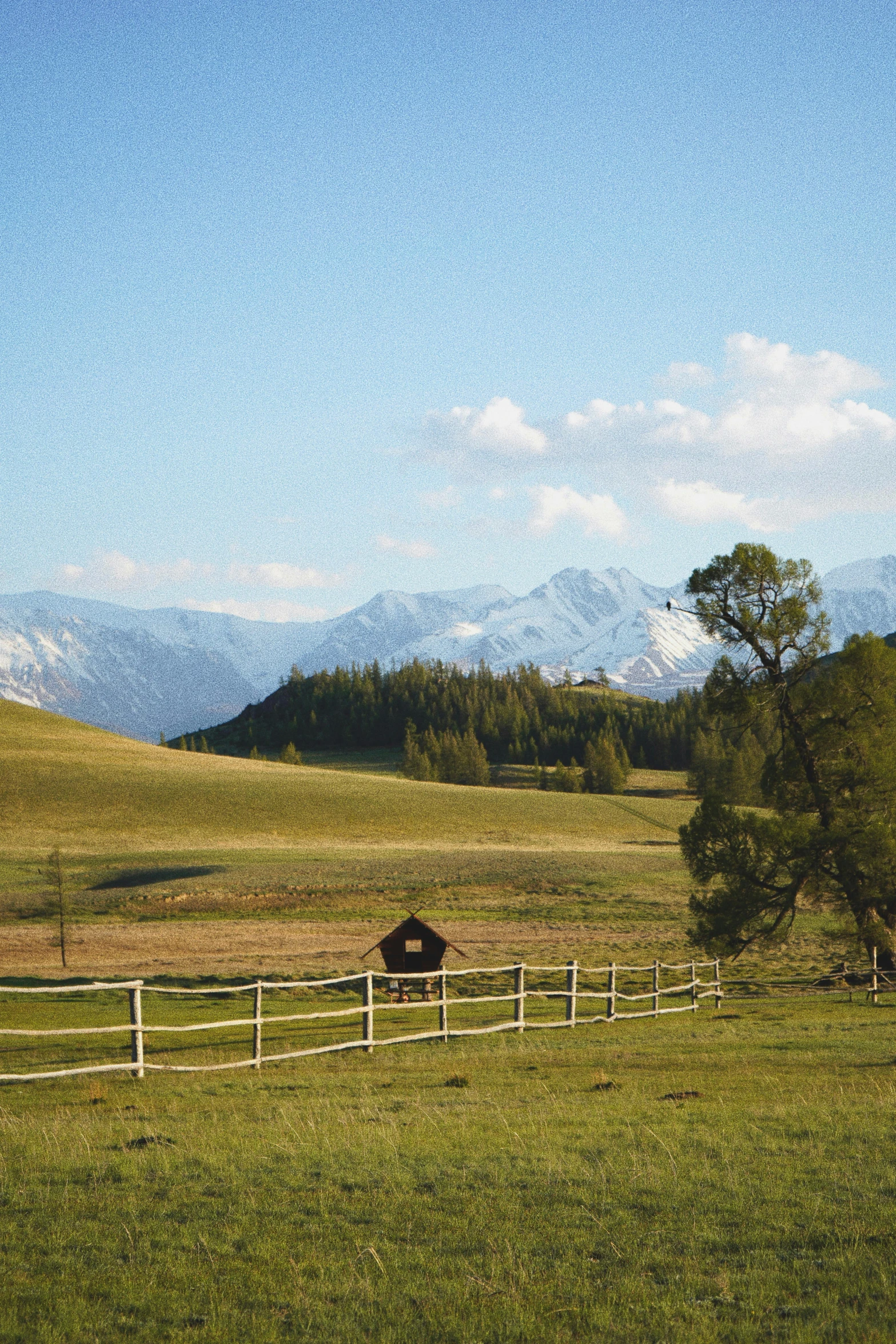 a fenced in pasture with mountains in the background, renaissance, west slav features, award winning scenery, exterior, iconic scene