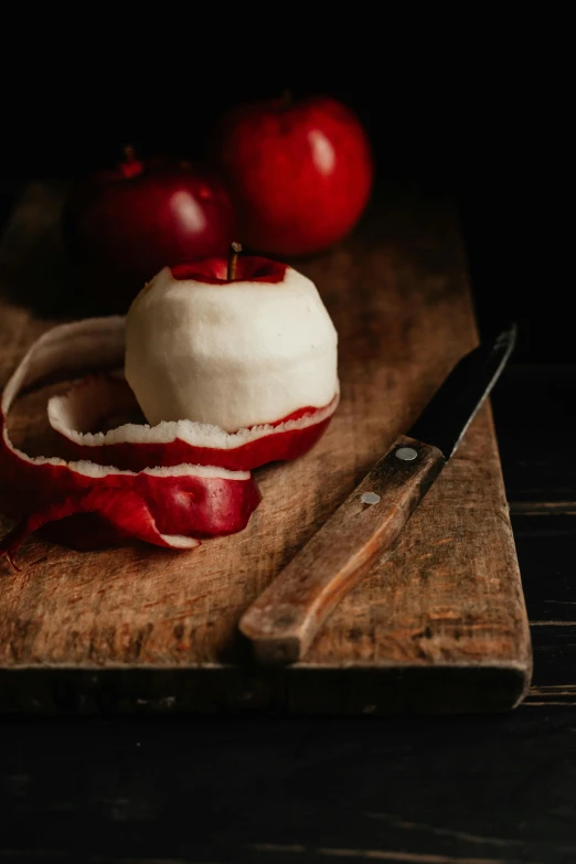 an apple sitting on top of a cutting board next to a knife, crimson themed, mozzarella, dramatic product shot, slide show