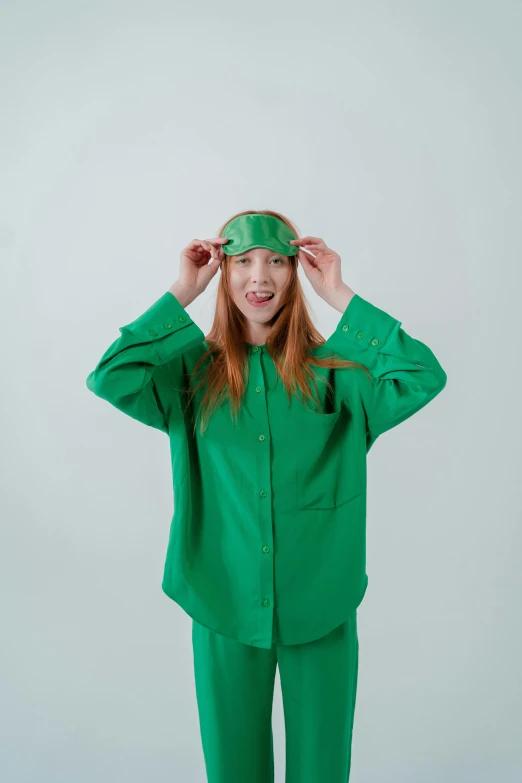 a woman in a green suit is covering her eyes, an album cover, inspired by Harriet Powers, trending on pexels, nurse costume, happy girl, young redhead girl in motion, wearing pajamas