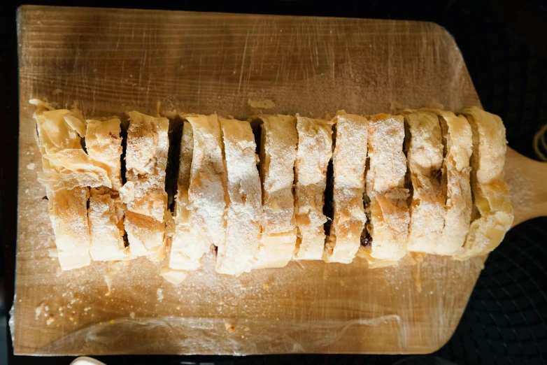 a loaf of bread sitting on top of a wooden cutting board, dessert, loose white braid, sparkling, thumbnail