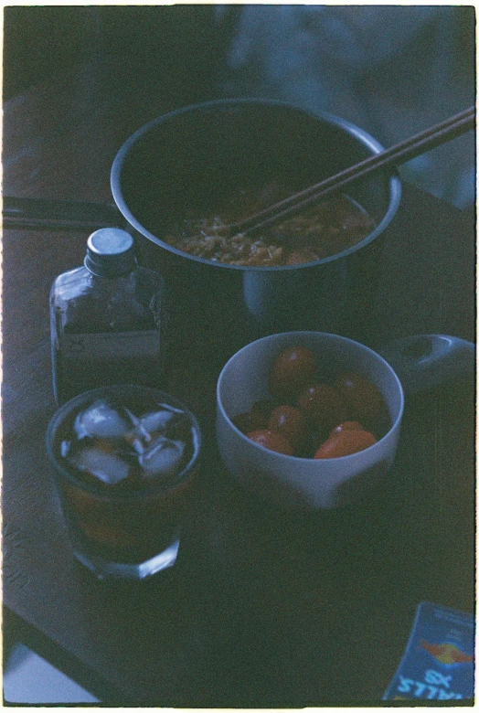 a couple of bowls of food sitting on top of a table, a still life, grainy photograph, midnight, pot, sauce