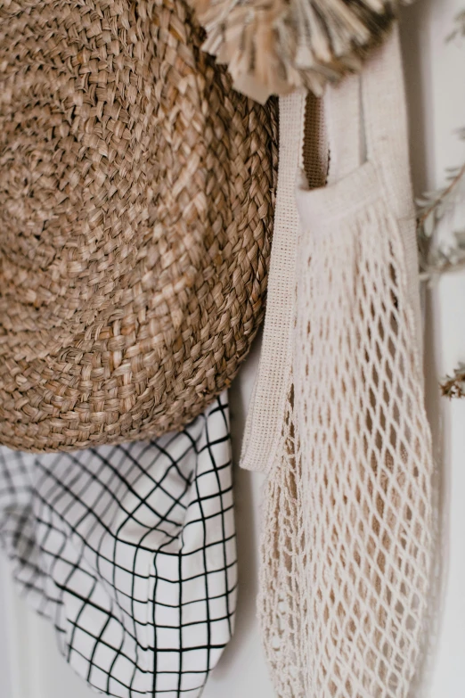 a close up of a bag hanging on a wall, by Nina Hamnett, trending on pexels, boho neutral colors, shopping groceries, grid and web, straw hat