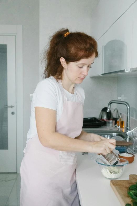 a woman standing in a kitchen preparing food, inspired by Anna Füssli, pexels contest winner, russian, profile image, pouring, low quality photo