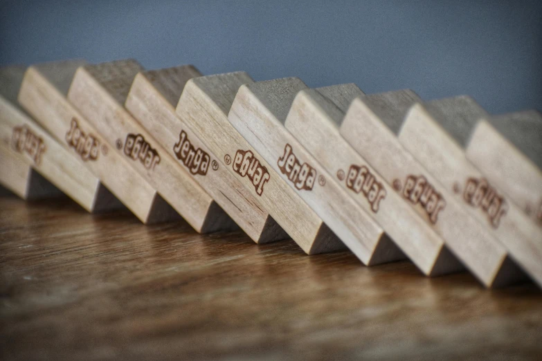 a row of wooden blocks sitting on top of a wooden table, inspired by Josef Block, happening, serrated point, engraved, sprigger, angled