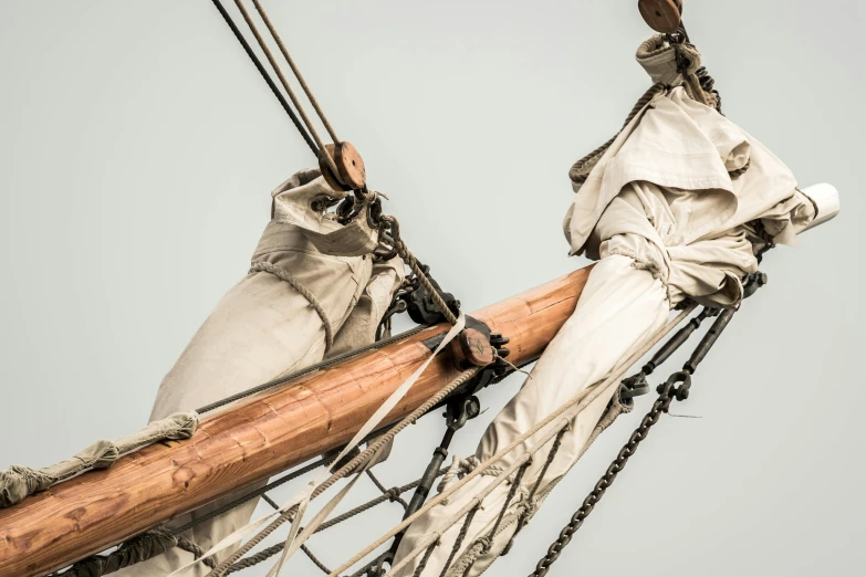 a bird sitting on top of a wooden pole, by John Gibson, pexels contest winner, romanticism, ships with sails underneath, in historic clothing, close up photograph, grey