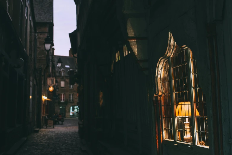 a person walking down a dark alley way, an album cover, inspired by Elsa Bleda, pexels contest winner, art nouveau, large windows to french town, in a medieval tavern at night, golden hour photo, empty streetscapes