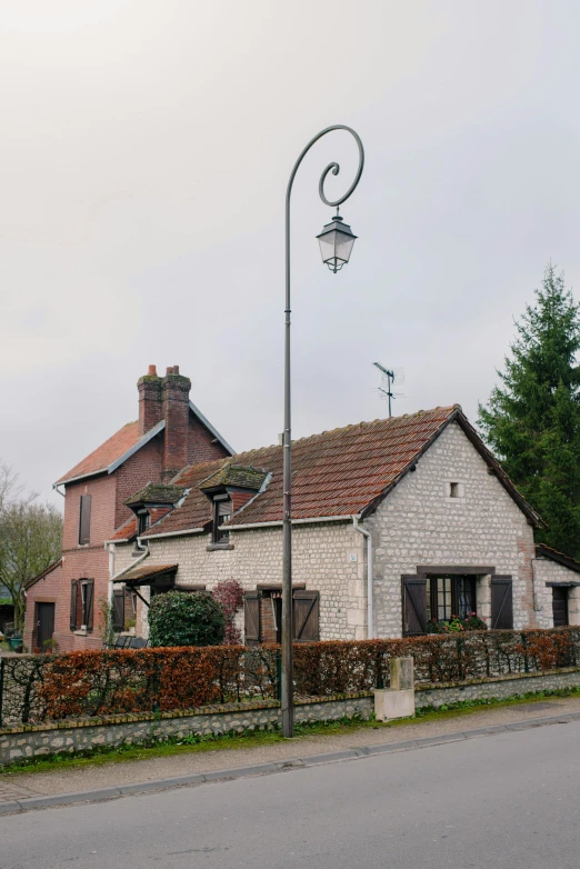 a street light sitting on the side of a road, inspired by Henri Harpignies, renaissance, small cottage in the foreground, central farm, 2019 trending photo, french village exterior
