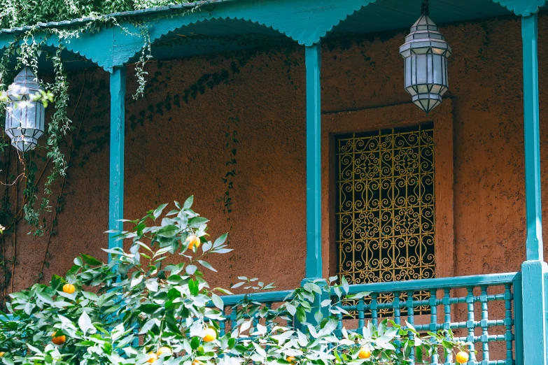 an orange tree is in front of a house, inspired by Riad Beyrouti, trending on unsplash, arts and crafts movement, cyan and gold scheme, lanterns on the porch, verdant and lush and overgrown, house in forest