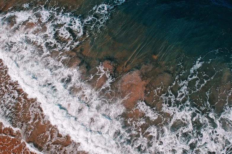 a person riding a surfboard on top of a sandy beach, pexels contest winner, satellite view, crashing waves, deeply hyperdetailed, rivulets