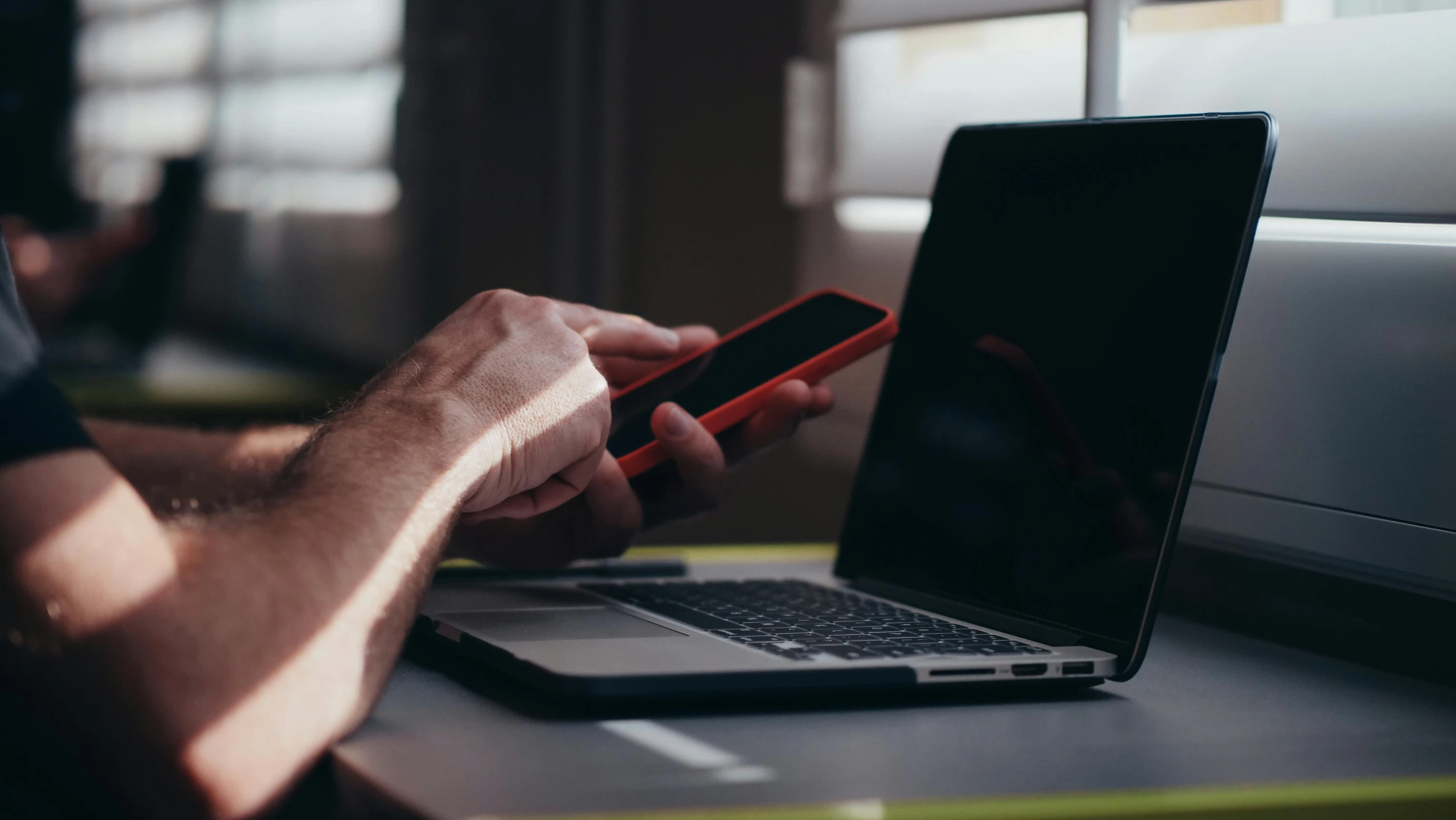 a man sitting at a desk with a laptop and a cell phone, a photo, by Carey Morris, pexels, worksafe. instagram photo, sitting on a red button, profile picture 1024px, thumbnail