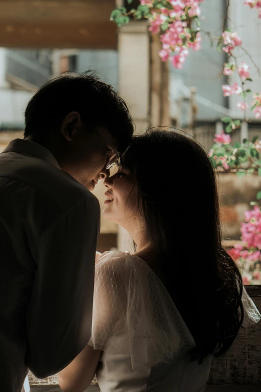 a man and a woman standing next to each other, pexels contest winner, romanticism, zeen chin and terada katsuya, making out, window light, flowers on heir cheeks