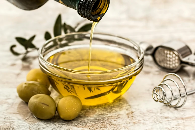 olive oil being poured into a bowl of olives, by Daniel Lieske, trending on unsplash, fan favorite, avatar image, glass tableware, leaked image