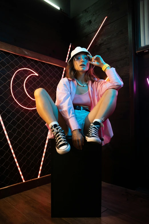 a woman sitting on a stool in front of a neon sign, trending on pexels, wearing white sneakers, pink clothes, wearing a chocker and cute hat, bisexual lighting
