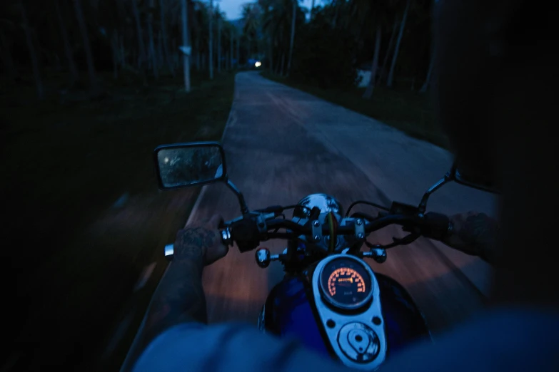 a person riding a motorcycle down a road at night, in a deep lush jungle at night, profile image, fan favorite, camera pov