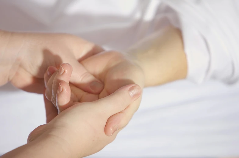 a close up of a person holding a child's hand, nerves and muscles, centred, relaxing, looking partly to the left