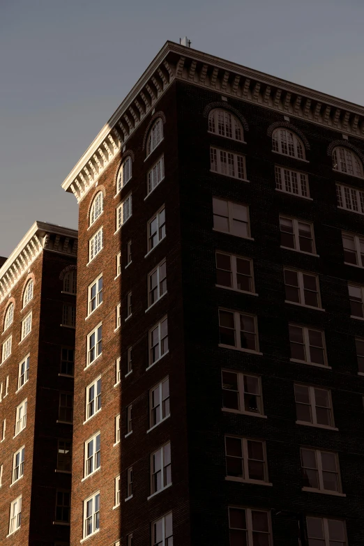 a tall brick building sitting next to a traffic light, by Adam Chmielowski, unsplash, late afternoon sun, haunted gothic hotel, panoramic shot, ignant