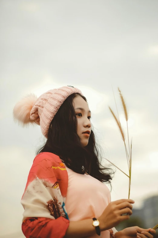 a woman standing on top of a lush green field, inspired by Oleg Oprisco, trending on pexels, beanie, young cute wan asian face, ((pink)), chilly