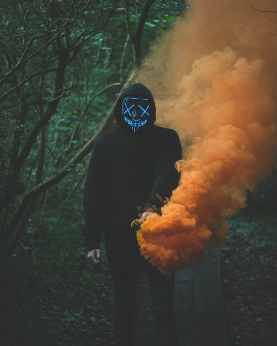 a person wearing a mask and holding a smoke bomb, discord profile picture, haunted woods, profile image, orange and cyan lighting