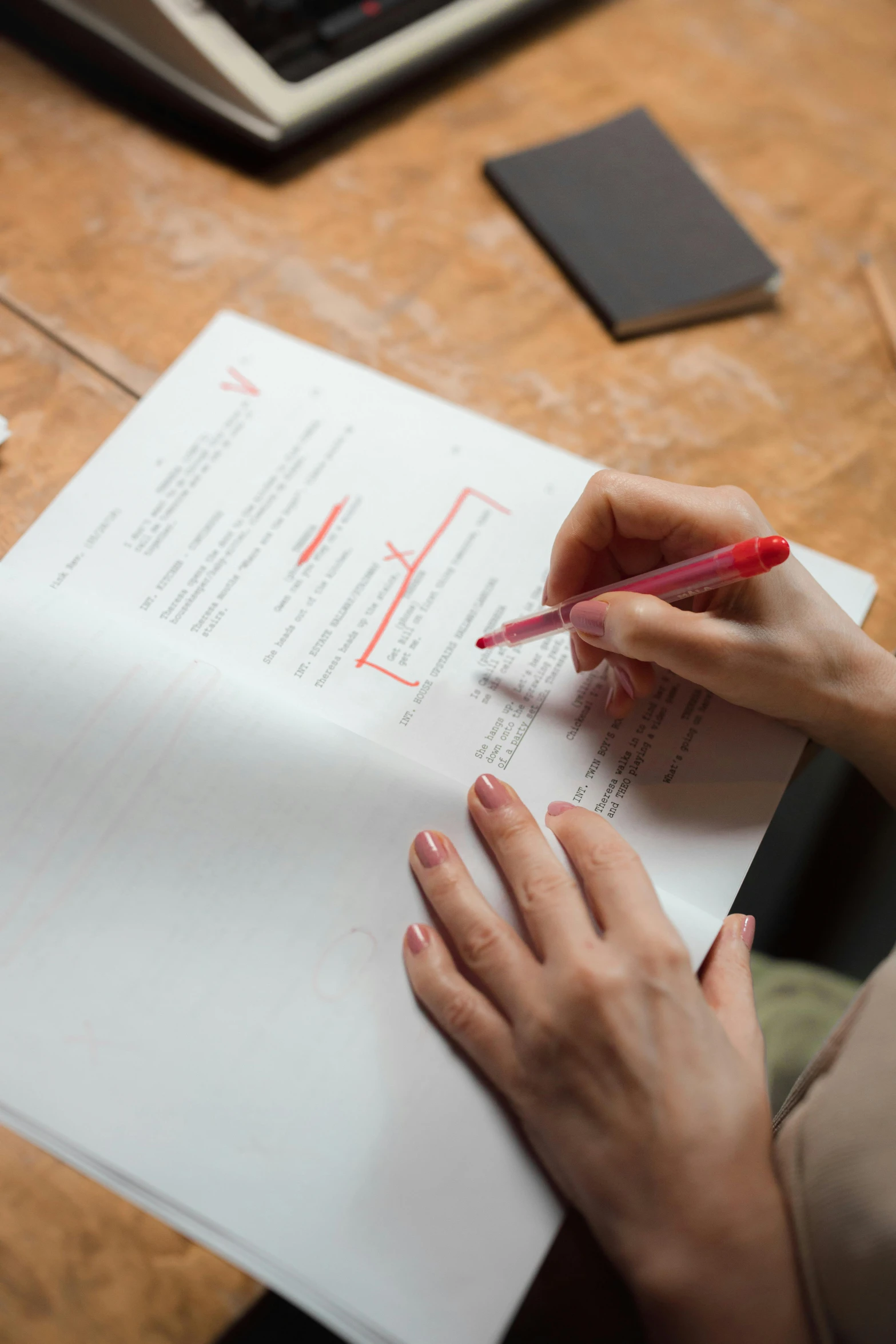 a woman sitting at a desk writing on a piece of paper, red writing, v tuber, on medium grade paper, textbook