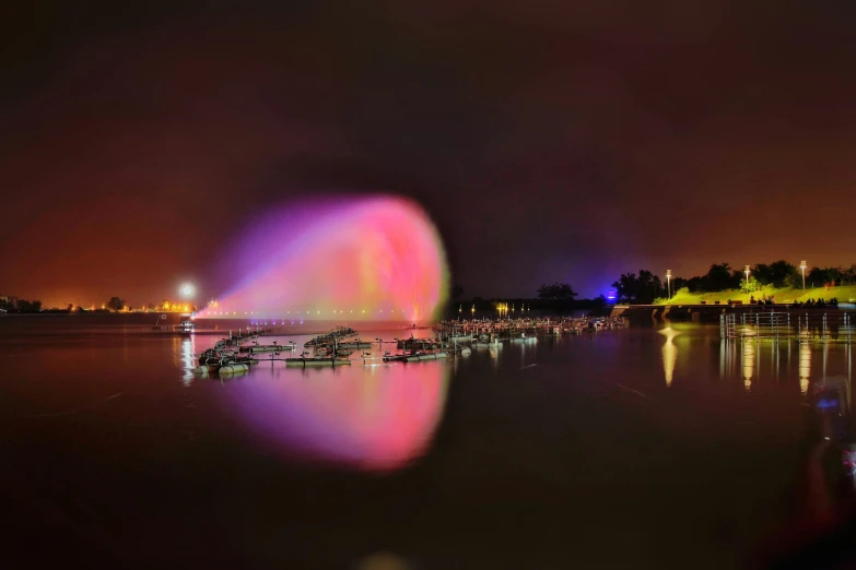 a person taking a picture of a water fountain, a hologram, by Cherryl Fountain, pexels contest winner, cai guo-qiang, colors reflecting on lake, long exposure outside the city, multiple purple halos