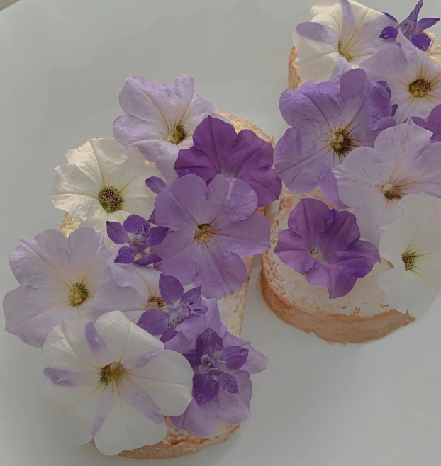 a white plate topped with purple and white flowers