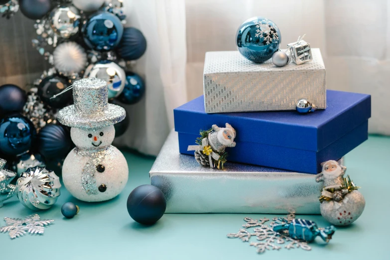 a pile of christmas presents sitting on top of a table, by Julia Pishtar, blue and silver, curated collections, frosty, from left