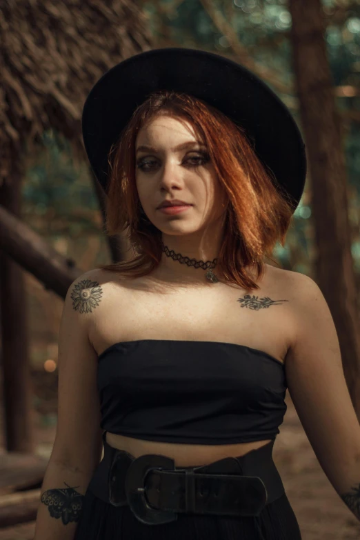 a woman with red hair wearing a black top and a hat, inspired by Elsa Bleda, pexels contest winner, croptop, young beautiful amouranth, wearing a native american choker, trees