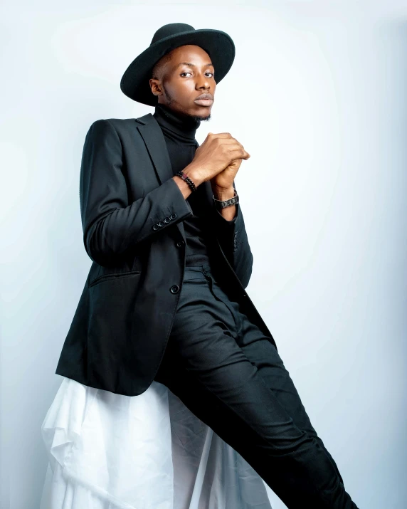 a man in a suit and hat sitting on a chair, an album cover, by Chinwe Chukwuogo-Roy, trending on pexels, lyco art, attractive androgynous humanoid, standing elegant pose, 3 / 4 pose, tall thin