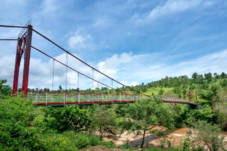 a red and white suspension bridge over a river, hurufiyya, vibrant greenery outside, avatar image, múseca illil, conde nast traveler photo