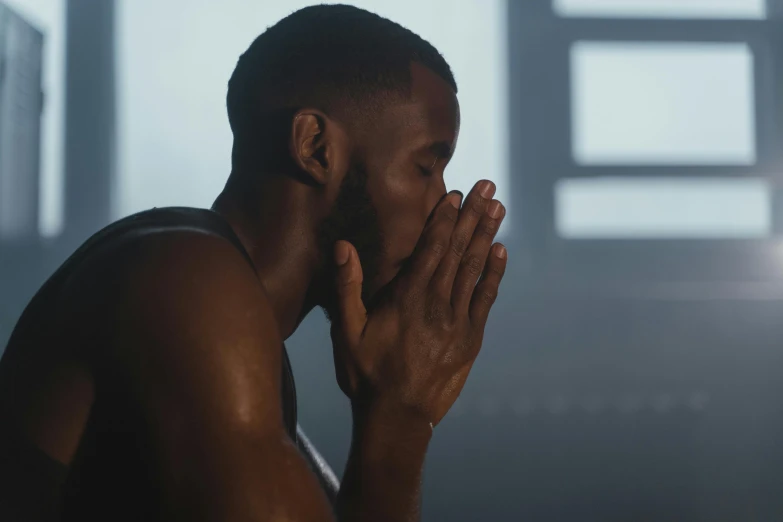 a man standing in front of a window with his hands on his face, inspired by Paul Georges, pexels contest winner, in a gym, praying, frank ocean, 2 0 2 1 cinematic 4 k framegrab