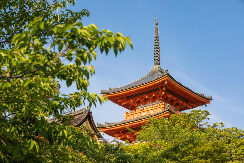 a tall pagoda surrounded by trees on a sunny day, inspired by Itō Jakuchū, trending on unsplash, lead - covered spire, vibrant foliage, conde nast traveler photo, exterior shot