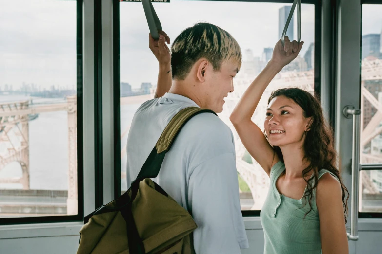 a man and a woman standing in front of a window, pexels contest winner, happening, raising an arm, tyler edlin and natasha tan, cute scene, 'wherever you go