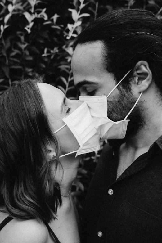 a man kissing a woman wearing a face mask, a black and white photo, by Lucia Peka, instagram picture, chemistry, zachary corzine, profile image