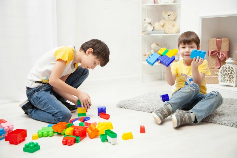 two young boys playing with blocks on the floor, a picture, shutterstock, instagram picture, plastic toy, promotional image, group photo