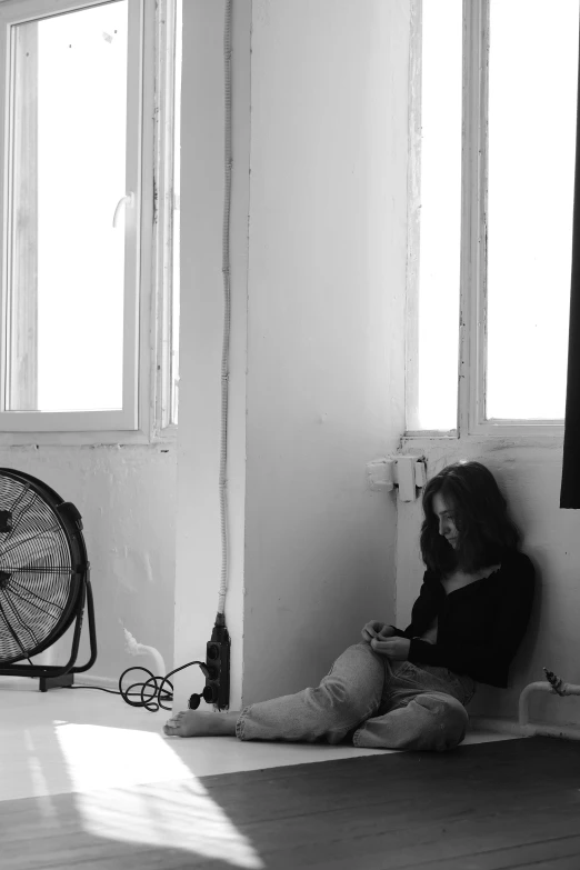 a black and white photo of a woman sitting on the floor, a black and white photo, flickr, in white room, taken in the late 2000s, cooling, yuli ban