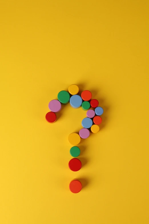 a question mark made of colored confetti on a yellow background, by artist, pexels contest winner, wooden art toys, circles, 15081959 21121991 01012000 4k, pills