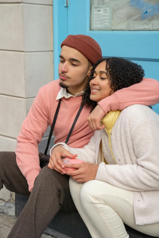 a man and a woman sitting on a bench, trending on pexels, renaissance, wearing a pastel pink hoodie, embrace, mixed race, leaning on door