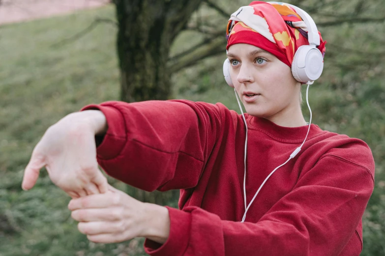 a young man wearing headphones and listening to music, an album cover, inspired by Louisa Matthíasdóttir, pexels, tai chi, wearing a head scarf, red sweatband, outdoor photo