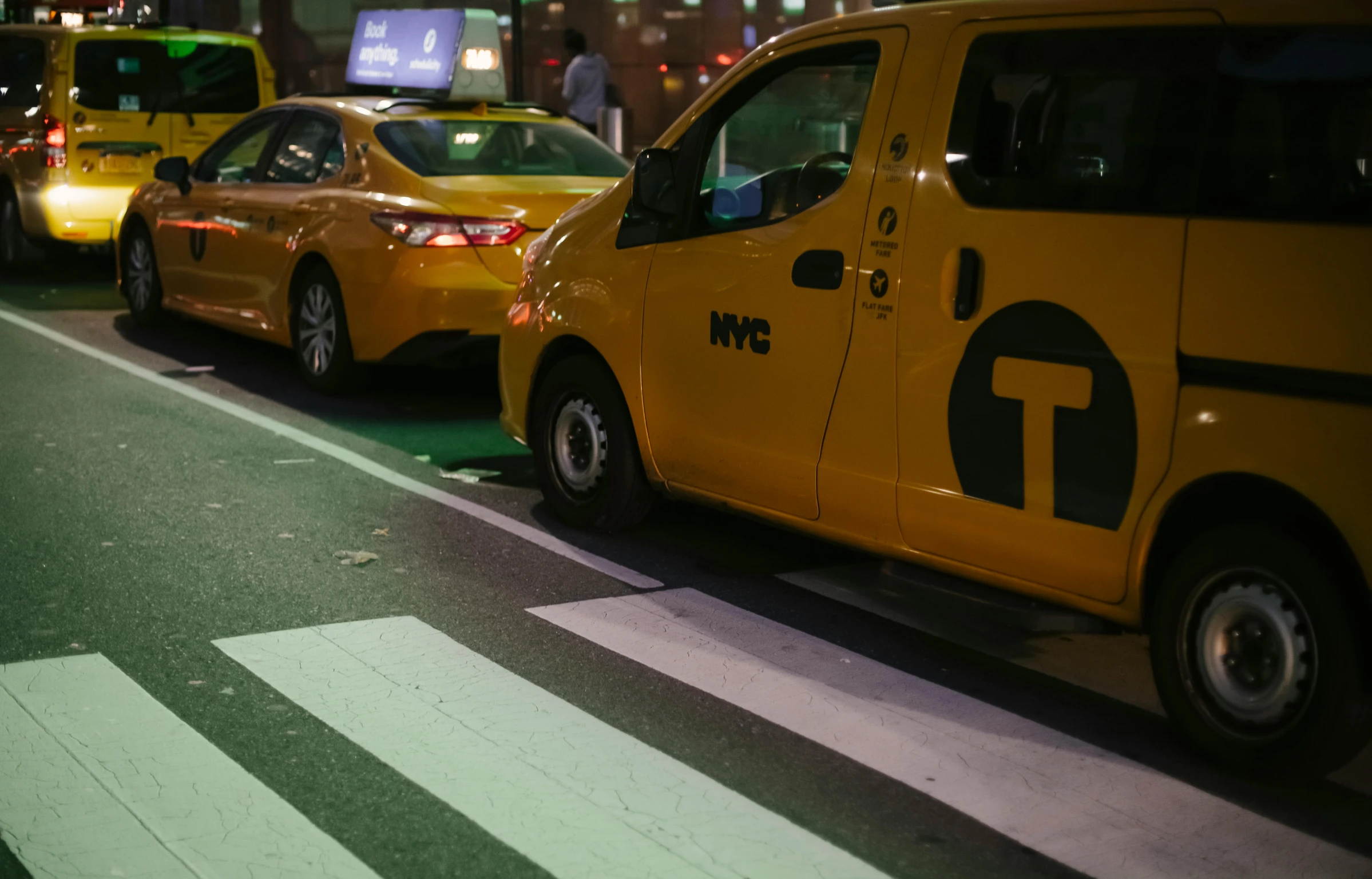 a number of taxis on a city street at night, trending on unsplash, square, new york times, low quality photo, yellow carpeted