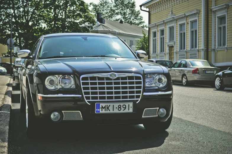 a black car parked on the side of the road, by Jaakko Mattila, pexels contest winner, renaissance, formal attire, silver crown, anato finnstark. front view, 🚿🗝📝